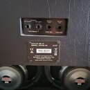 Zadní strana černého kytarového reproduktoru s povrchem imitujícím kůži. Horní panel obsahuje čtyři vstupy s nápisy STEREO 8Ω RIGHT, STEREO 8Ω LEFT,…