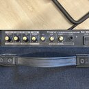 Detail ovládacího panelu černého komba s nápisy Roland, 4-CH MIXING KEYBOARD AMPLIFIER a KC-150. Panel obsahuje čtyři kanály (CH 1 MIC/LINE, CH 2 LIN…
