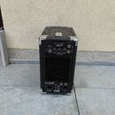 Zadní strana černého kytarového komba s kovovými rohy a madlem. Na zadním panelu je nápis CUB - GUITAR AMPLIFIER CUB-AG100 a logo Roland. V dolní čás…