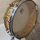 Dřevěný buben s kovovým obručováním a průhlednou membránou. Na korpusu je nápis YAMAHA Maple Custom a na membráně logo REMO s textem WEATHER KING AMB…