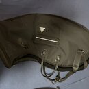 Černý polstrovaný obal na hudební nástroj s rukojetím a ramenním popruhem. Na přední kapsi je bílé trojúhelníkové logo s nápisem "TAMA". Povrch mater…