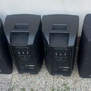 Čtyři černé reproduktorové boxy, dva z nich jsou zakryté černými textilními kryty. Na přední straně krytů je bílé logo a nápis soundsation. Viditelné…