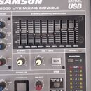 Detailní pohled na míchací pult s nápisy SAMSON, 24 FX DSP DIGITAL EFFECTS a 2000 LIVE MIXING CONSOLE USB. Zařízení obsahuje stereo grafický ekvalizé…