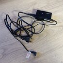Černý síťový adaptér s dlouhým kabelem a koncovkou pro zásuvku. Na těle adaptéru je bílý nápis CUBE-STD-R. Na kabelu se nachází bílá nálepka s textem…