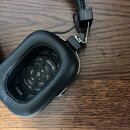 Černé centerXlupující sluchátka s oválnými polštáři z umělé kůže. Vnitřní strana mušle obsahuje černou kovovou mřížku s kruhovým vzorem. Na fotce nej…