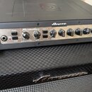 Černý basový zesilovač značky Ampeg, model PF-800 z řady Portaflex. Přední panel je stříbrný s ovládacími prvky, včetně nápisů mute, peak mute, thres…