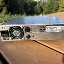 Zadní strana stříbrného zesilovače s kovovým povrchem. Na zařízení jsou vidět nápisy Markbass, CE a štítek s údaji Model LITTLE MARK VINTAGE AMP, S/N…
