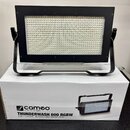 Černý LED panel s mřížkou drobných světelných bodů, umístěný na černém kovovém stojanu. Zařízení stojí na bílém kartonovém obalu, na kterém je nápis…