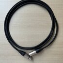 Černý instrumentální kabel sletovaný do kruhu. Má kovové konektory a na povrchu kabelu je bílý nápis "SSC-THE STAGE 25". Kabel i konektory vykazují m…