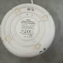 Fotografie zachycuje spodní stranu bílého kulatého zařízení z plastu. Uprostřed je náleplka s textem: „Dohm Sound Conditioner Schlafhilfe SleepMate A…
