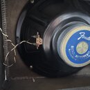 Fotografie zachycuje zadní část černého reproduktoru s namontovaným magnetem. Na modrém štítku magnetu je bílý nápis Fender a text MUSICAL INSTRUMENT…