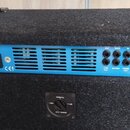 Zadní strana basového komba v černém textilním potahu. Modrý ovládací panel nese nápisy EBS GORM ET, 250 WATTS PROFESSIONAL BASS COMBO a DESIGNED AND…