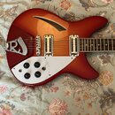 Červená elektrická kytara s semi-hollow korpusem a bílým pickguardem. Na kytaru jsou instalovány dva humbuckery a čtyři ovládací knofíky. Na kovovém…