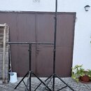 Černý kovový stojan s dvěma teleskopickými nožemi a dvěma vodorovnými rameny. Povrch laku je v několika místech odřený a vykazuje známky opotřebení.…