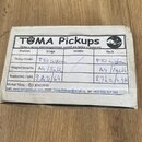 Fotografie znázorňuje kartonové krabičky s nalepeným bílým štítkem. Na štítku je nápis TUMA Pickups a text Výroba a opravy elektromagnetických snímač…
