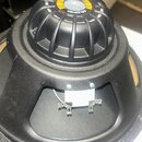 Černý reproduktor s plastovým žebrovaným krytem magnetu. Na horní části krytu je žlutý štít s nápisy CELESTION a BN12-3009. V otvore v rámu jsou vidě…