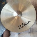 Kruhový mosazný činel s viditelným broušením povrchu. Na spodní části je černý nápis Zildjian. Povrch vykazuje drobné nevýrazné skvrny a oxidaci.