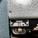 Detail zadní strany přístroje s šedým strukturovaným povrchem. Na černém plastovém panelu je štítek s nápisy TESLA, MADE IN CZECHOSLOVAKIA, AZK 904,…
