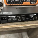 Zadní strana černého elektronického zařízení s nápisem Digitech. Na panelu jsou vidět konektory pro napájení, USB, Footswitch, Expression a Controlle…