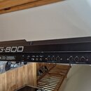 Detailní pohled na zadní panel černé klávesové stanice s nápisem Roland G-800. Jsou vidět různé konektory a popisky: LED CONTRAST, SUSTAIN FOOTSWITCH…