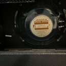 Fotografie zachycuje zadní stranu reproduktoru v černém rámu. Uprostřed je bílá nálepka s nápisy JENSEN MUSIC INDUSTRIES, JENSEN SPECIAL DESIGN a tex…