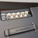 Černý kytarový kombozesilovač s texturovaným povrchem. Na ovládacím panelu je nápis DV MARK a řada bílých otočných ovladačů s popisky DRIVE, BASS, MI…