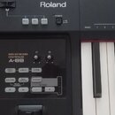 Černý MIDI kontrolér s klávesnicí. Na horním panelu je bílý nápis Roland a tlačítka PITCH, VOL, ASSIGN a POWER. V ovládací sekci jsou nápisy MIDI KEY…