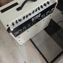 Bílý kytarový kombozesilovač s černou ovládací panelí a černou rukojetí. Na předním panelu je uveden model 5150® ICONIC SERIES a logo EVH®. Povrch př…