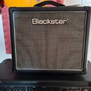 Černý kytarový kombo zesilovač s texturovaným povrchem a stříbrnou přední síťovkou. Uprostřed horní části je bílý nápis Blackstar. Zesilovač stojí na…