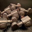 Sada kovových ladicích mechanismů stříbrné barvy. Na každém mechanismu je vyražen nápis GROVER. Povrch kovů vykazuje známky opotřebení a oxidace.