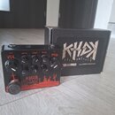 Černý efekt pedál s červenými grafickými prvky a nápisy. Na horní straně jsou čtyři ovládací knoflíky s popisky VOL, DRIVE, TONE a FREQ a jeden menší…