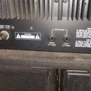 Zadní panel černého elektronického zařízení s chladicími žebry. Jsou zde nápisy 220-240V ~ 50-60Hz, PRIMARY FUSE AC250V T 3.0A a CONSUMPTION 510 WATT…