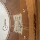 Detail dřevěného bubnu s bílým koženem značky REMO TEXTURE COATED. Na korpusu je nalepený štítek s nápisy Hallvad drums, Snare drum 14" x 6 1/2" soli…