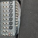 Zadní strana šedého rackového zařízení s řadou vstupů a výstupů. Na panelu jsou viditelné nápisy BEHRINGER a model H244XL USB. Jsou zde konektory XLR…