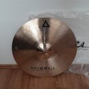 Kruhový činel z bronzu s viditelným broušením povrchu. Na horní části je logo trojúhelníku a nápis XIST, ve spodní části nápisy istanbul® a Agop Made…