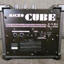 Zadní strana černého kytarového komba s nápisem MICRO CUBE. Na spodním panelu jsou konektory REC OUT/PHONES, AUX IN a DC IN s dopisem USE BOSS PSA-E3…