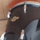 Černý buben s chromovaným obručováním a lugy. Na korpusu je oválný štítek s nápisy Pearl, Masters a PREMIUM MAPLE. Na horním a dolním obruči je nápis…
