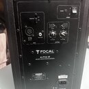 Zadní strana černého studiového monitoru značky FOCAL PROFESSIONAL, model ALPHA 65 MUSIC MONITORING SYSTEM. Horní panel obsahuje vypínač POWER s kont…