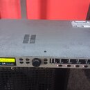 Stříbrný rackový procesor s černým horním krytem. Na předním panelu je digitální displej se zeleným textem "M 013 B24 ID *Default*", nápisy "DX 24 48…