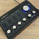 Černý audio rozhraní s nápisem AUDIOFUSE STUDIO. Zařízení obsahuje čtyři vstupní kanály označené jako INPUT CHANNEL 1 až 4, každý s vlastními přepína…