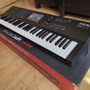 Černý klaviaturní kontrolér Akai Professional MPC KEY 61 s bílými a černými klávesami. Na horní části je umístěn displej, ovládací knofíky a sady pad…