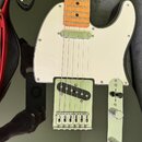 Černá elektrická kytara typu Telecaster s bílým pickguardem a světle hnědým javorovým hmatníkem. Nástroj má jeden krkový snímač a jeden mostový sníma…
