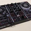 Černý DJ kontrolér značky Numark s dvěma stříbrnými jog-koly. Na přístroji jsou viditelné nápisy Numark, PARTY MIX a označení kanálů 1 a 2. Zařízení…