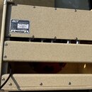 Zadní strana basového komba v béžovém texturovaném potahu. Na horním panelu je umístěn štítek s nápisy: HOT CUSTOM AMPLIFICATION, Model Bassguy 115 2…