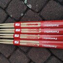 Čtyři páry dřevěných bubeníckých paliček v červených papírových obalech. Na obalech je bílý nápis Fantastick, The economy hit a dále USA HICKORY a mo…