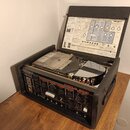 Černý efektový procesor Roland RE-201 Chorus Echo v ochranném přepravním kufru s otevřeným víkem. Na předním panelu jsou vidět ovládací knofíky, přep…