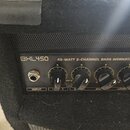 Detail ovládacího panelu černého basového komba. Na panelu je nápis BXL450 45-WATT 2-CHANNEL BASS WORKSTATION, vstup INPUT a čtyři otočné ovladače s…