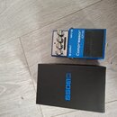 Modrý efekt pedál s nápisy Compressor, CP-1X a BOSS. Zařízení má čtyři ovládací knoflíky, červenou kontrolku a vstupy označené INPUT a OUTPUT. Vedle…