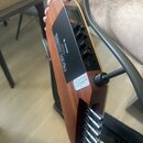 Detail zadní strany hnedu hnědé elektrické violy z dřeva. Na černém ovládacím panelu je nápis ROHNER, značka CE a text MADE IN GERMANY. Panel obsahuj…