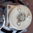 Detailní pohled na zadní část reproduktoru s kovovým magnetem stříbrné barvy. Na černém štítku je uveden nápis VER KOMBINAT STERNRADIO BERLIN ELEKTRO…